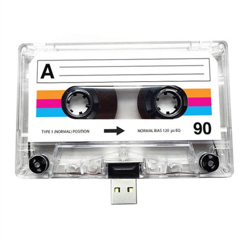 May include: A clear plastic cassette tape with a black USB drive attached. The cassette tape has a label that says "A" and "90". The cassette tape is a type 1 normal position and has a normal bias 120 us EQ.