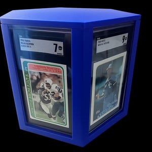 Puede incluir: Una vitrina azul que contiene dos tarjetas deportivas calificadas. Las tarjetas presentan im&aacute;genes de jugadores de f&uacute;tbol americano. La vitrina tiene forma cuadrada y es de color azul liso. Las tarjetas est&aacute;n en protectores.