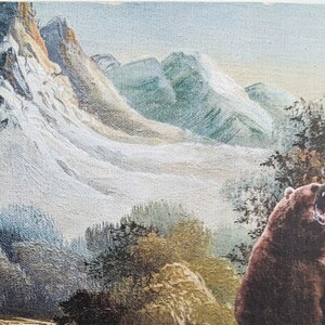 May include: A brown bear with its mouth open roaring in a mountain landscape. The bear is in the foreground of the image, with a snowy mountain range in the background.