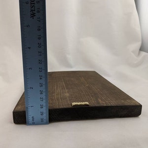 May include: A dark brown wooden sign with a brass hanging hook. The sign is approximately 29 inches long.