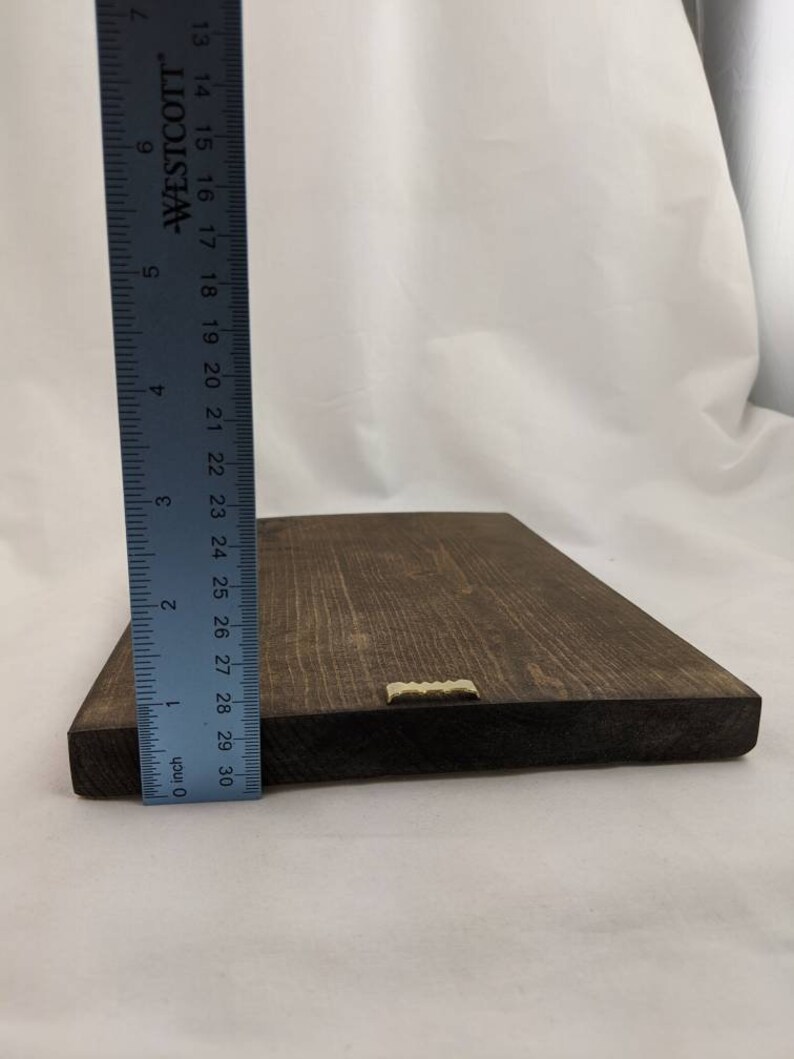 May include: A dark brown wooden sign with a brass hanging hook. The sign is approximately 29 inches long.