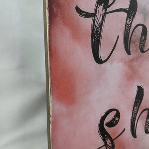 May include: A wooden sign with a pink and white watercolor background. The sign has black calligraphy that reads "So thankful".