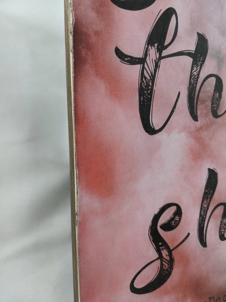 May include: A wooden sign with a pink and white watercolor background. The sign has black calligraphy that reads "So thankful".