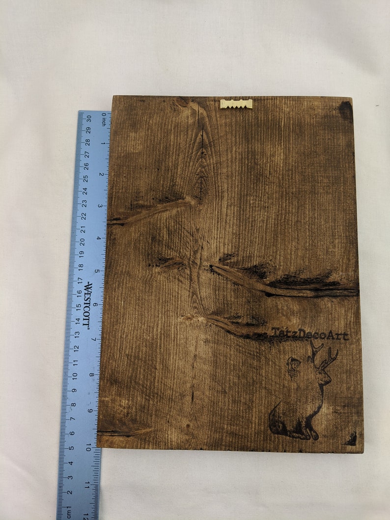 May include: A dark brown wooden sign with a burnt-in image of a deer and the text "TatzDecoArt".