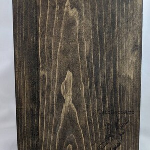 May include: A dark brown wooden sign with a hanging hook on the top. The sign has a black and white logo with the text "TalzDecoArt" and a stylized image of a deer.