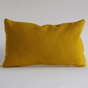 May include: A mustard yellow throw pillow with a subtle textured fabric.