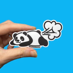 May include: A white and black panda sticker with a cloud-shaped fart graphic. The panda is lying down with a smiling face. The sticker has the text "@KawaiiRogue" at the bottom. The background is a solid blue.