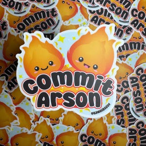 May include: A sticker with two cartoon flames with faces, and the text "Commit Arson" in black letters. The flames are orange and yellow, and the background is light blue with white stars.