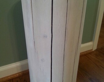 Puede incluir: Taburete de madera blanco con forma cilíndrica y un acabado rústico y desgastado. El taburete está hecho de tablones de madera individuales que se han unido para crear un aspecto único y natural.