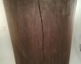 Può includere: Uno sgabello in legno marrone scuro realizzato da un tronco d'albero. Lo sgabello ha un aspetto naturale e rustico con motivi di venature e crepe visibili.