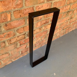 Op de afbeelding: Zwart metalen tafelpoot met een rechthoekige vorm. De poot is gemaakt van stevig metaal en heeft een eenvoudig, modern ontwerp.