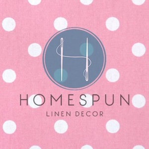 Peut inclure: Tissu rose &agrave; pois blancs avec un logo qui dit "HOMESPUN LINEN DECOR". Le logo repr&eacute;sente une lettre stylis&eacute;e "H" avec deux aiguilles qui se croisent.