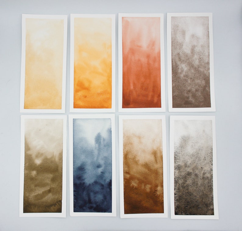 May include: Eight watercolor paintings on paper, each with a different color gradient. The colors are yellow, orange, red, brown, green, blue, tan, and gray.