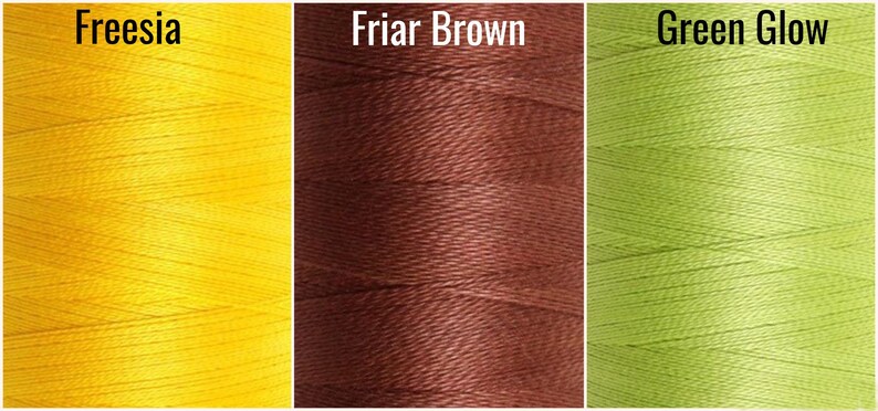 May include: Three spools of thread in different colors: yellow, brown, and green. The thread is wound tightly and has a smooth texture.