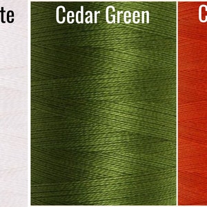 May include: Three spools of thread in different colors: bleached white, cedar green, and celosia orange.