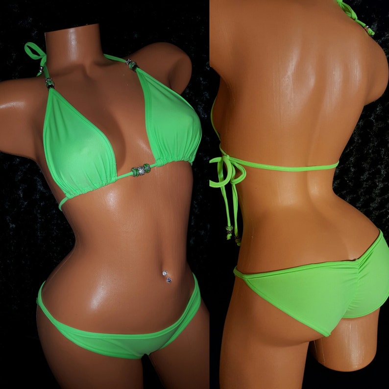 May include: A neon green bikini with a halter top and a low-rise bottom. The bikini has rhinestones on the straps and center front of the top.