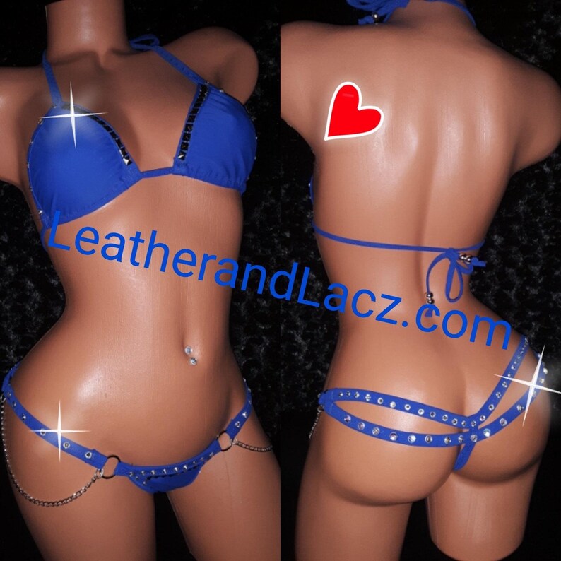 May include: A royal blue two-piece lingerie set with rhinestones. The bra has a halter style and the matching panty has a chain detail. The set is shown on a mannequin.