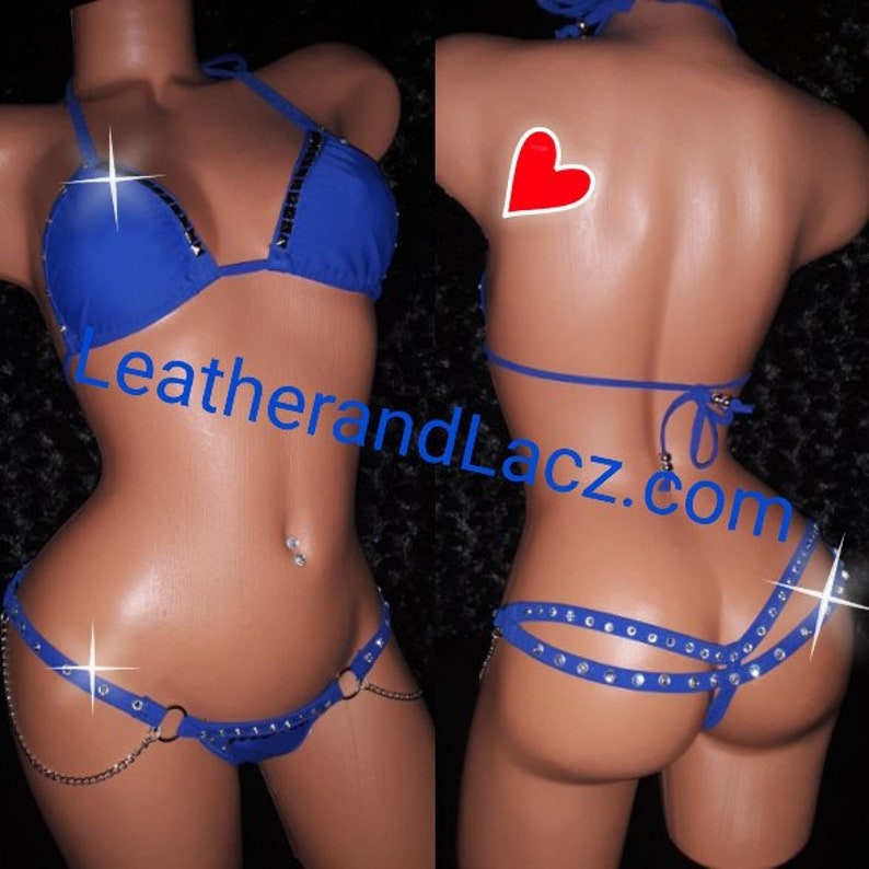 May include: A blue bikini set with rhinestones. The top is a triangle style with adjustable straps. The bottom is a cheeky style with a chain detail. The bikini is shown on a model.