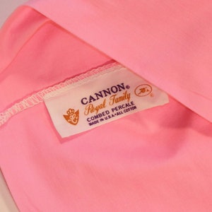 May include: A pink fabric label with the text "CANNON&reg; Royal Family Combed Percale Made in U.S.A. - All Cotton" in black and purple lettering.