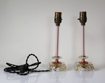 Pair of clear glass boudoir lamps with pink center column, bakelight accent and black twisted fabric cord