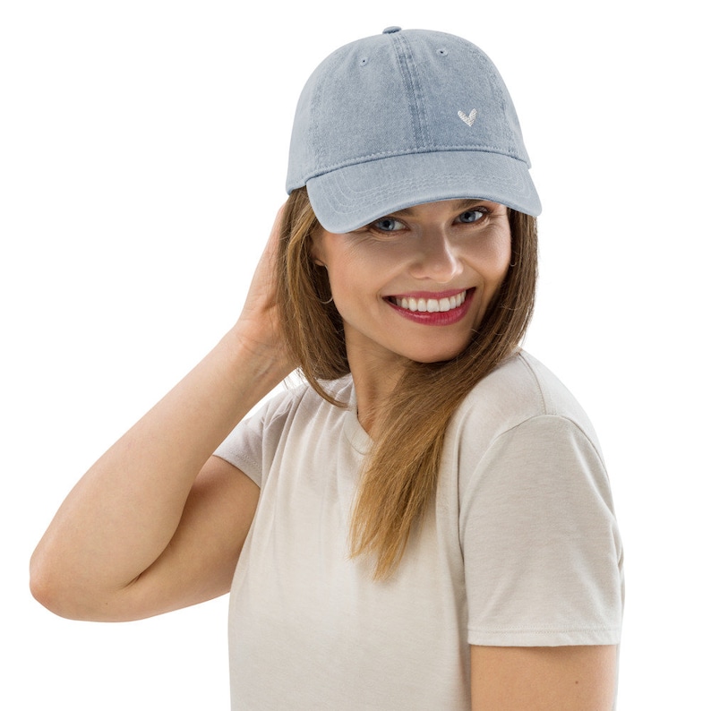 May include: A light blue denim baseball cap with a white embroidered V on the front.