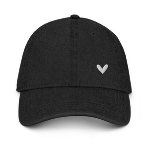 May include: A black baseball cap with a small white heart embroidered on the front.