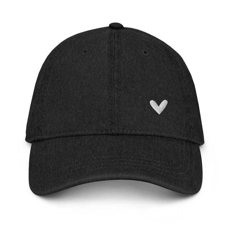 May include: A black baseball cap with a small white heart embroidered on the front.