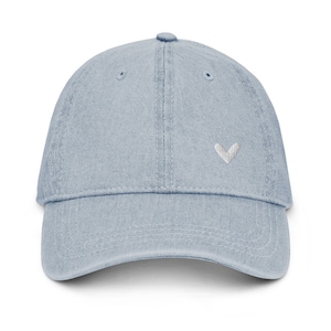 May include: A light blue denim baseball cap with a small white heart embroidered on the front.