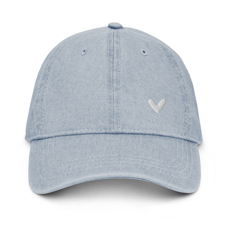 May include: A light blue denim baseball cap with a small white heart embroidered on the front.