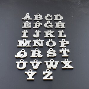 May include: Silver alphabet letter charms, each letter is a separate charm. The letters are arranged in alphabetical order from A to Z.