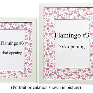 May include: Two white picture frames with flamingo-themed patterned borders. The frames have white matting and openings for 10x15 cm and 13x18 cm photos. Text on the frames reads "Flamingo #3" and indicates the opening sizes. The image is in portrait orientation.