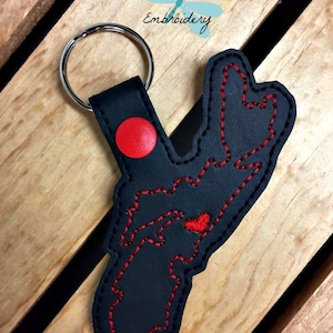 May include: Black leather keychain with a red stitched outline of the state of Rhode Island. The keychain has a red heart in the centre of the state and a red circle on the top.