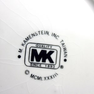 May include: A white ceramic plate with a black and white logo that reads "M. Kamenstein, Inc. Taiwan Quality MK Since 1893 &copy; MCM LXXXXIII"