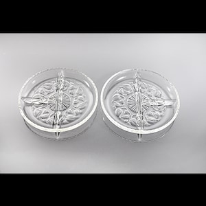 Puede incluir: Dos platos de servir divididos de vidrio transparente con un patrón floral decorativo. Los platos están divididos en cuatro secciones.