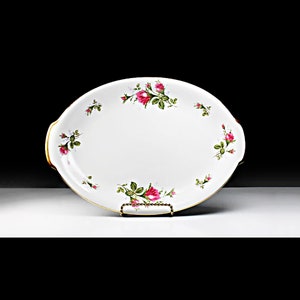 Puede incluir: Plato de servir ovalado blanco con borde dorado y un delicado patr&oacute;n floral de rosas rosas y hojas verdes.