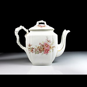 May include: White porcelain teapot with a floral design and gold accents. The teapot has a lid and a handle.