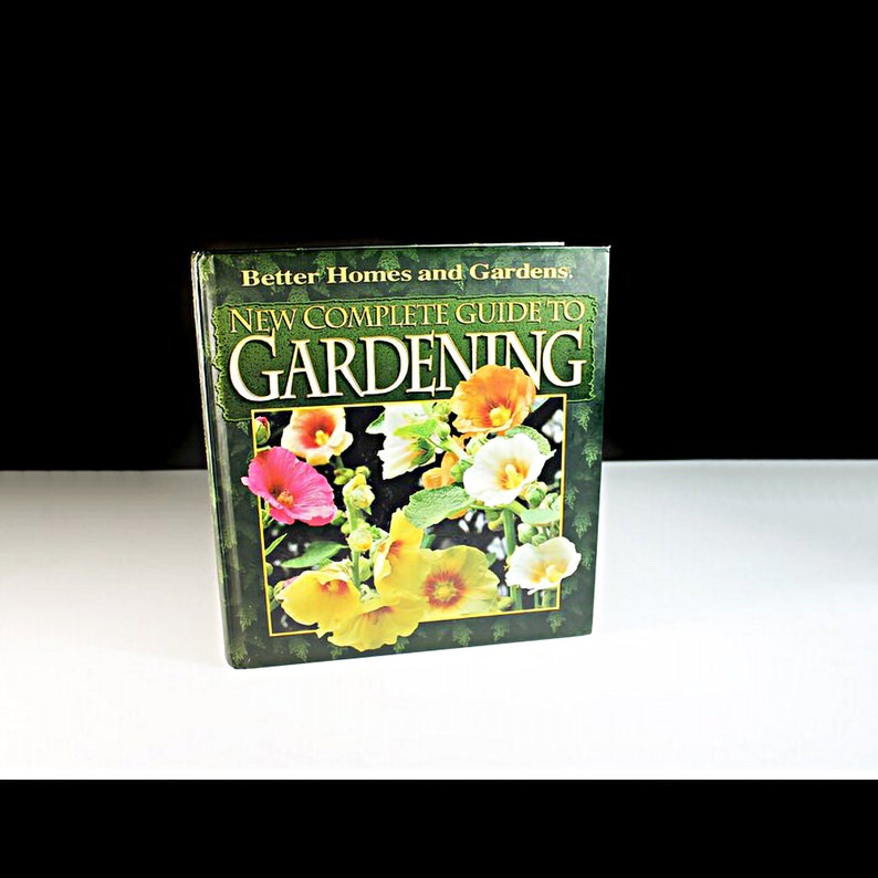 May include: A green book titled "New Complete Guide to Gardening" by Better Homes and Gardens. The cover features a close-up of colorful flowers.