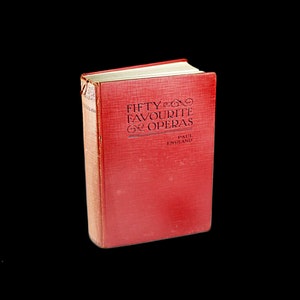 Puede incluir: Un libro de tapa dura rojo titulado "Fifty Favourite Operas" de Paul England.