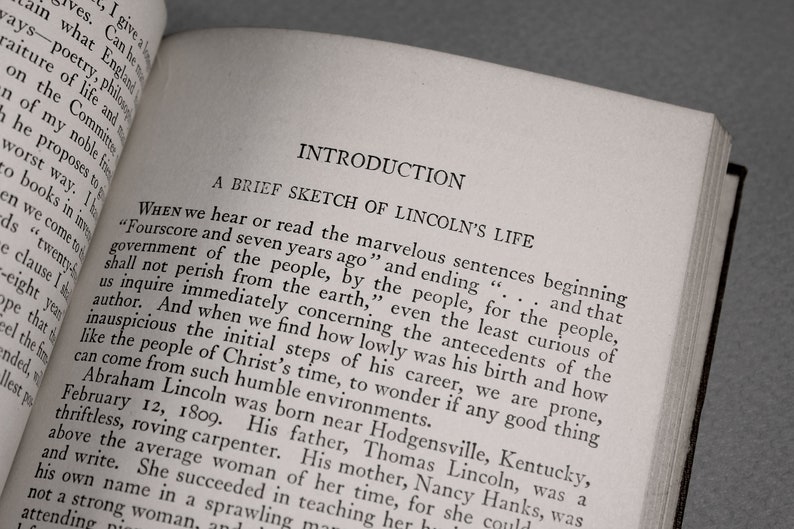Op de afbeelding: Een zwart-wit boek met de titel "Inleiding: Een kort overzicht van Lincolns leven" op de omslag. De tekst op de pagina begint met de quote "Fourscore and seven years ago..." en gaat verder met een beschrijving van Abraham Lincolns vroege leven.