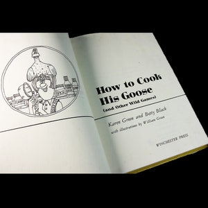May include: Open book with the title "How to Cook His Goose (and Other Wild Games)". The book's cover features a cartoon illustration of a chef and a goose. The author's names are Karen Green and Betty Black. Published by Winchester Press.