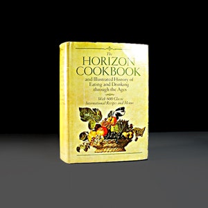Puede incluir: La portada del libro de cocina Horizon presenta un fondo amarillo con el título "The Horizon Cookbook" en texto negro. El subtítulo es "and Illustrated History of Eating and Drinking through the Ages" en texto negro más pequeño. La portada también presenta una cesta de frutas y verduras, incluyendo uvas, manzanas, peras y ciruelas.