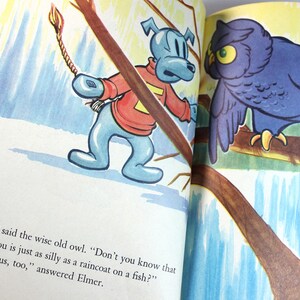 May include: An illustration of a blue dog with a red sweater and a long tail, and a purple owl perched on a branch. The dog is holding a rope with a lit match on the end. The text reads, "Silly boy," said the wise old owl. "Don't you know that a long tail on you is just as silly as a raincoat on a fish?" "You're jealous, too," answered Elmer.
