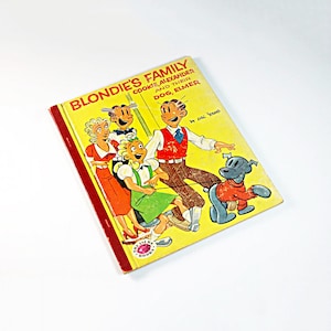 May include: A vintage children's book titled "Blondie's Family, Cookie, Alexander and Their Dog, Elmer" by Chic Young. The cover features a cartoon illustration of Blondie and her family, including a dog.