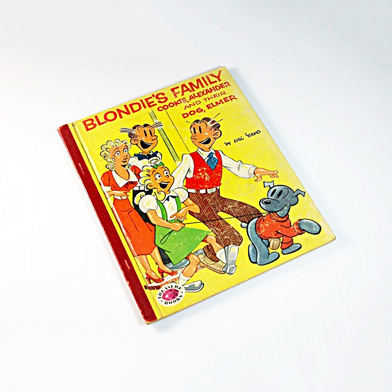May include: A vintage children's book titled "Blondie's Family, Cookie, Alexander and Their Dog, Elmer" by Chic Young. The cover features a cartoon illustration of Blondie and her family, including a dog.