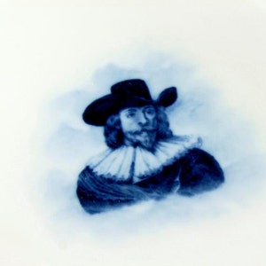 May include: A blue and white porcelain plate with a portrait of a man in a hat and a ruff collar.