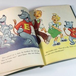 May include: An open book with a cartoon illustration of a dog with a long tail. The dog is wearing a red sweater with a white letter E on it. The text in the book reads "How do I look, boys?" and "That tail is silly. Elmer is no pointer - he's not even a bloodhound."