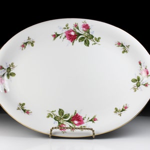 Puede incluir: Plato de servir ovalado blanco con borde dorado y dise&ntilde;o floral con rosas rosas y hojas verdes.