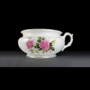 May include: White ceramic chamber pot with a pink rose floral design and a gold trim around the rim.