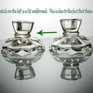 Puede incluir: Dos candelabros de vidrio transparente con base festoneada. El candelabro de la izquierda est&aacute; ligeramente deformado. Nota: El candelabro de la izquierda est&aacute; un poco deformado. Esto se debe a que son hechos a mano