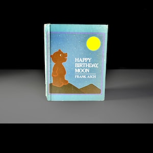May include: A children's book titled "Happy Birthday, Moon" by Frank Asch. The cover features a brown bear, a yellow moon, and text on a blue background. The book is a children's story.